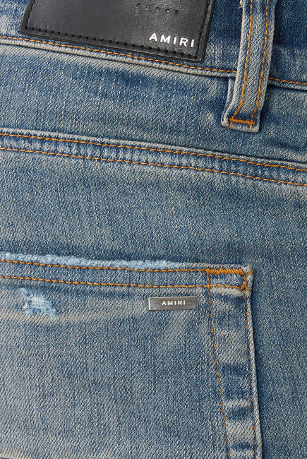 بنطال جينز بتفاصيل ممزقة وشعار الماركة