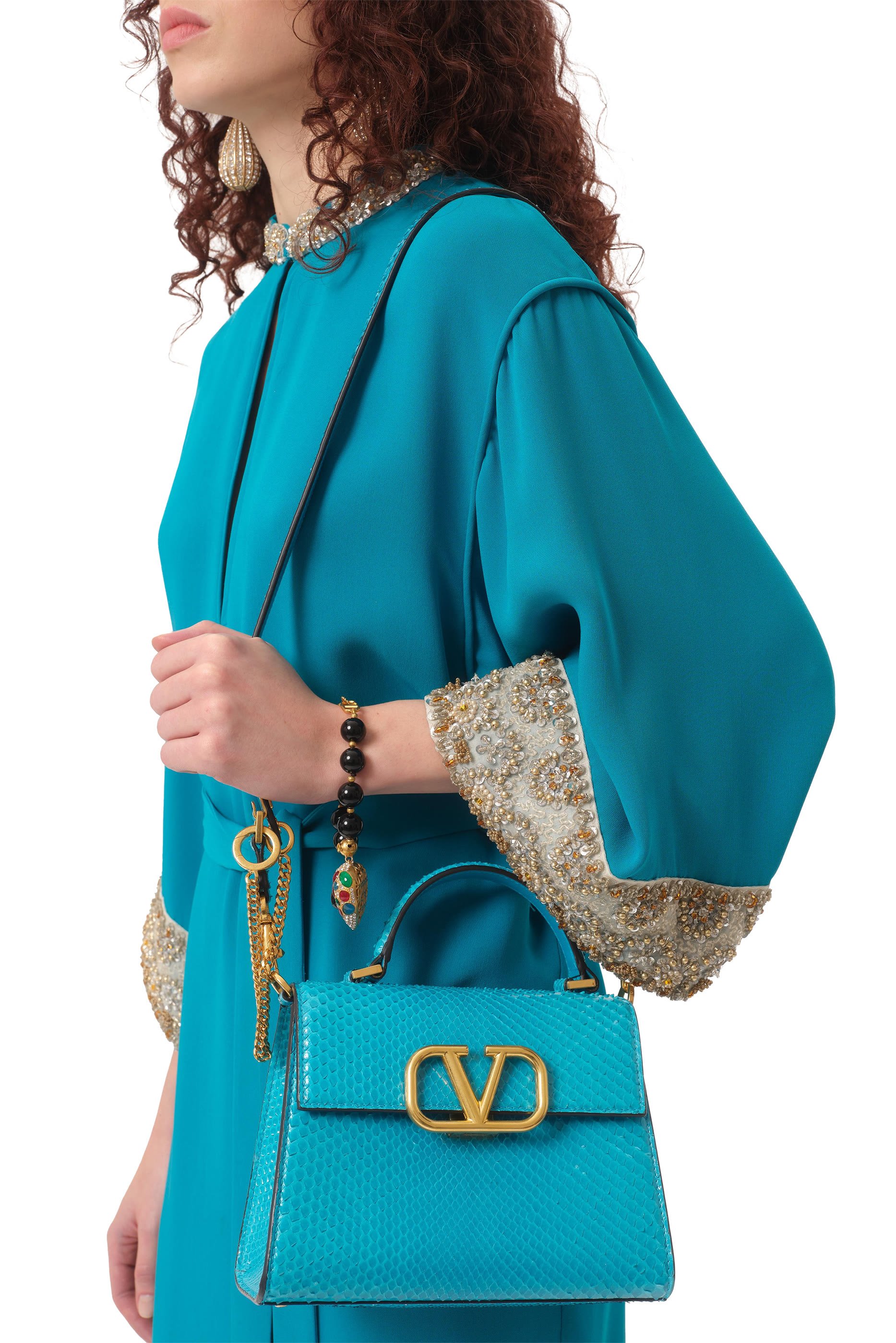 حقيبة صغيرة بيد علوية وشعار حرف الماركة