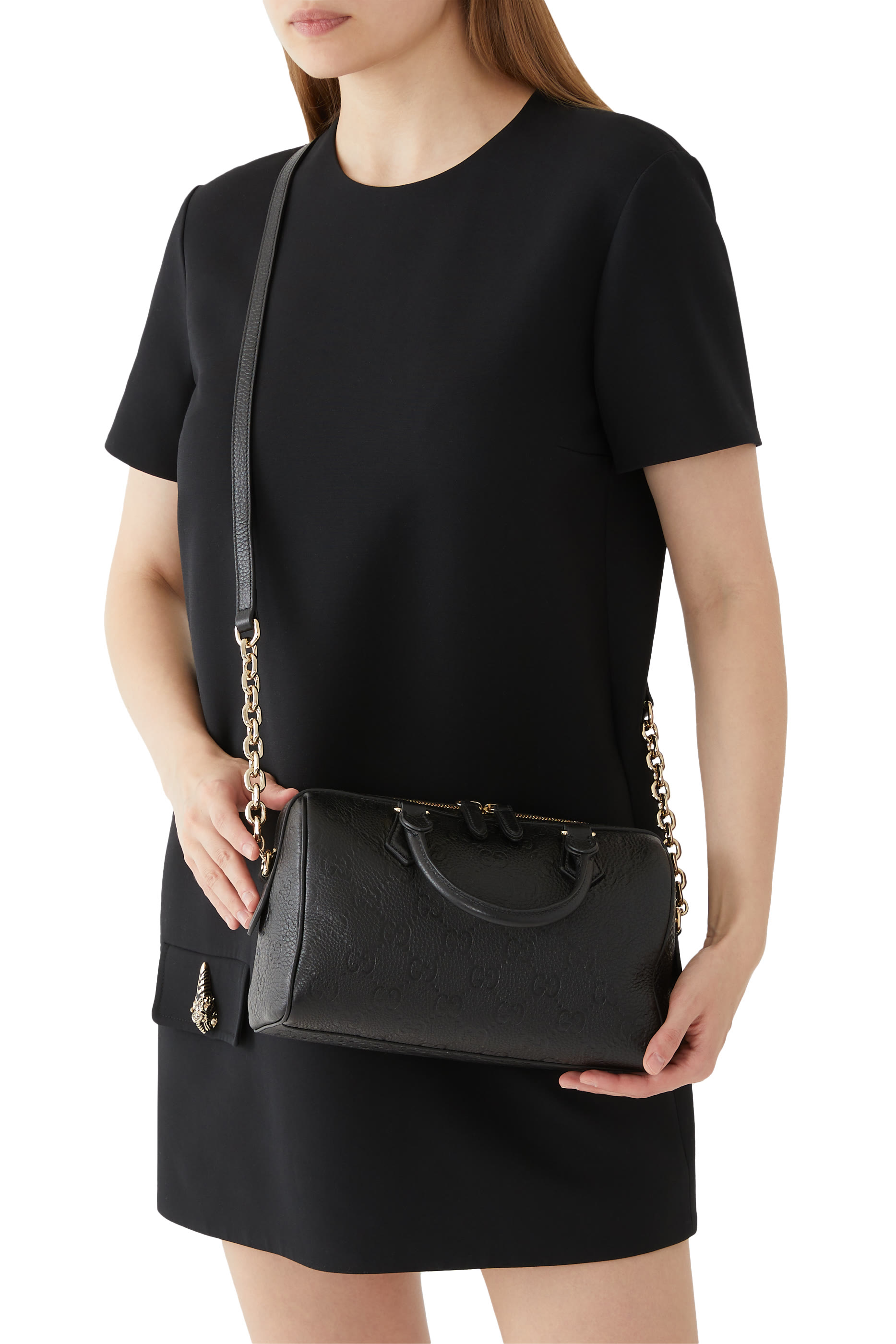 حقيبة صغيرة بيد علوية ونقشة حرفي شعار الماركة