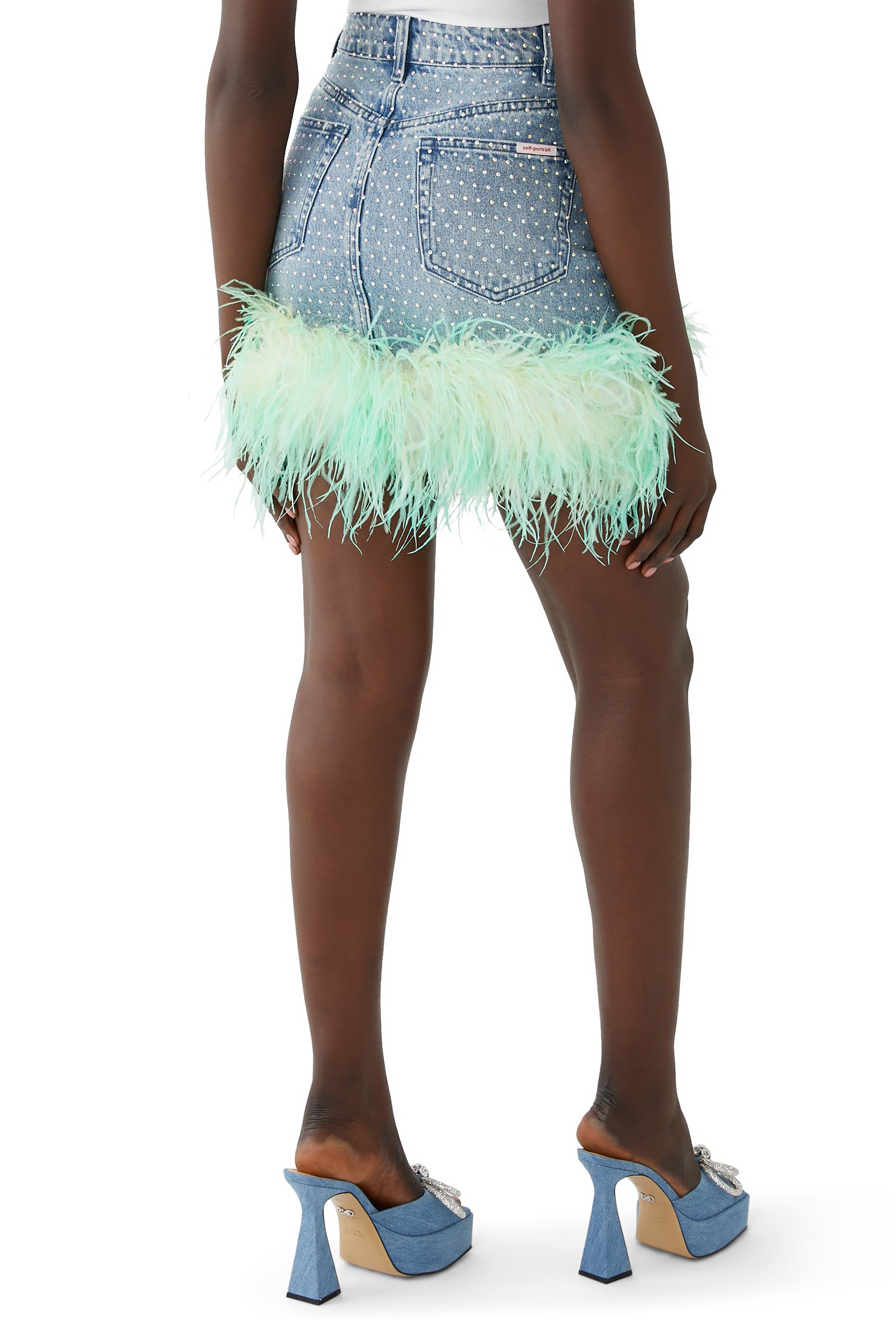 تنورة دنيم مزينة بأحجار الراين والريش