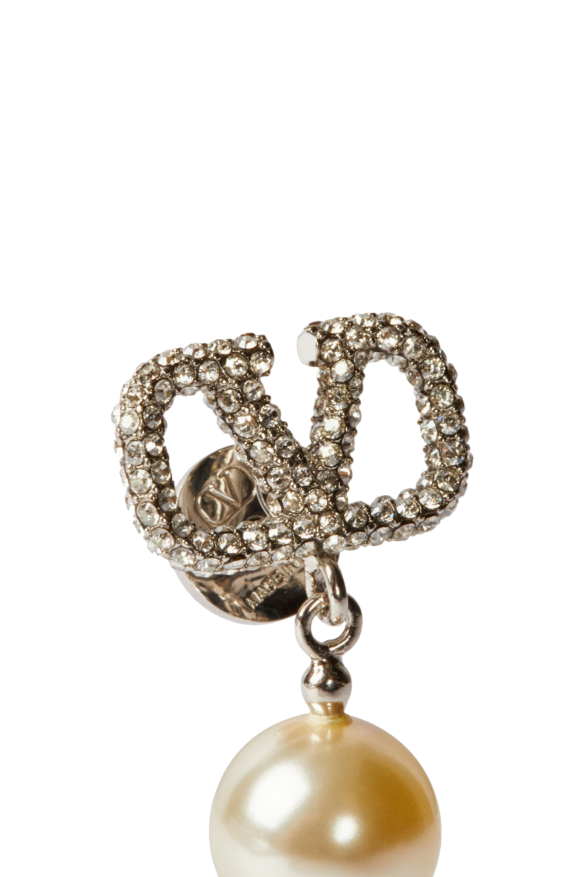 أقراط بتصميم شعار الماركة مرصعة باللؤلؤ