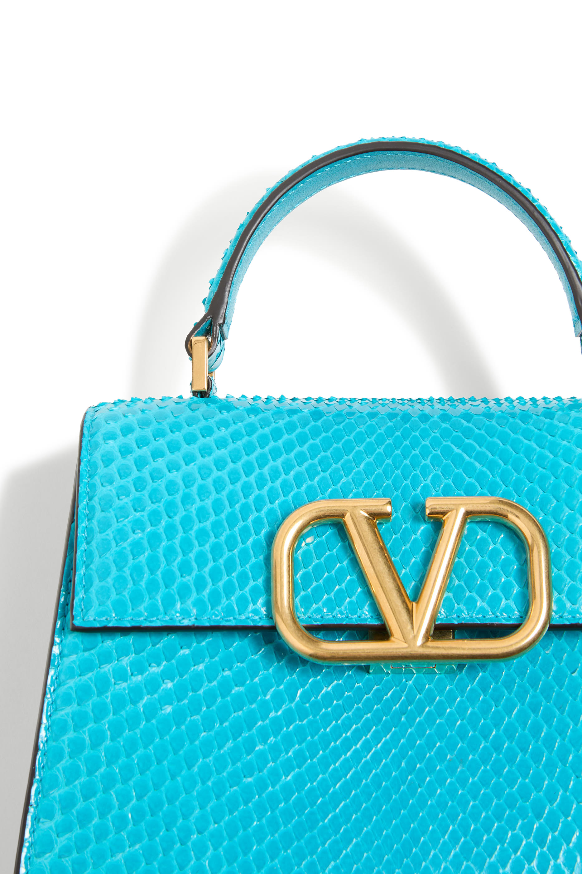 حقيبة صغيرة بيد علوية وشعار حرف الماركة