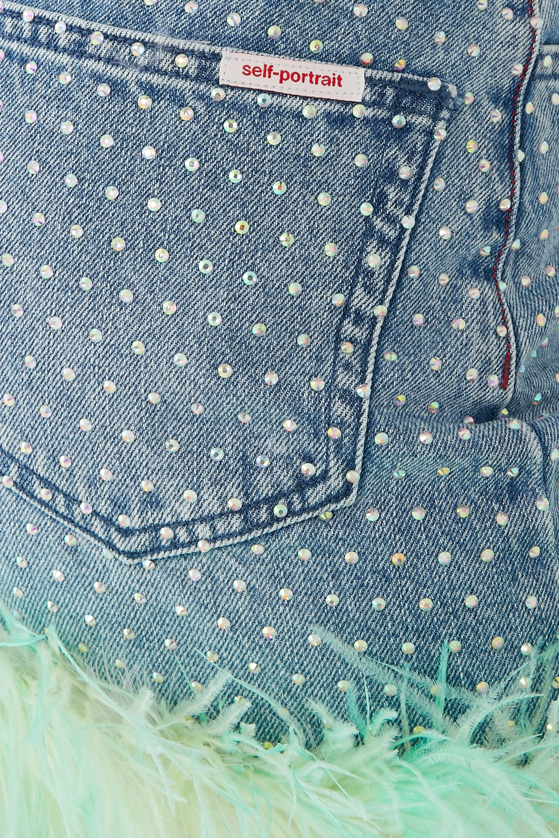 تنورة دنيم مزينة بأحجار الراين والريش