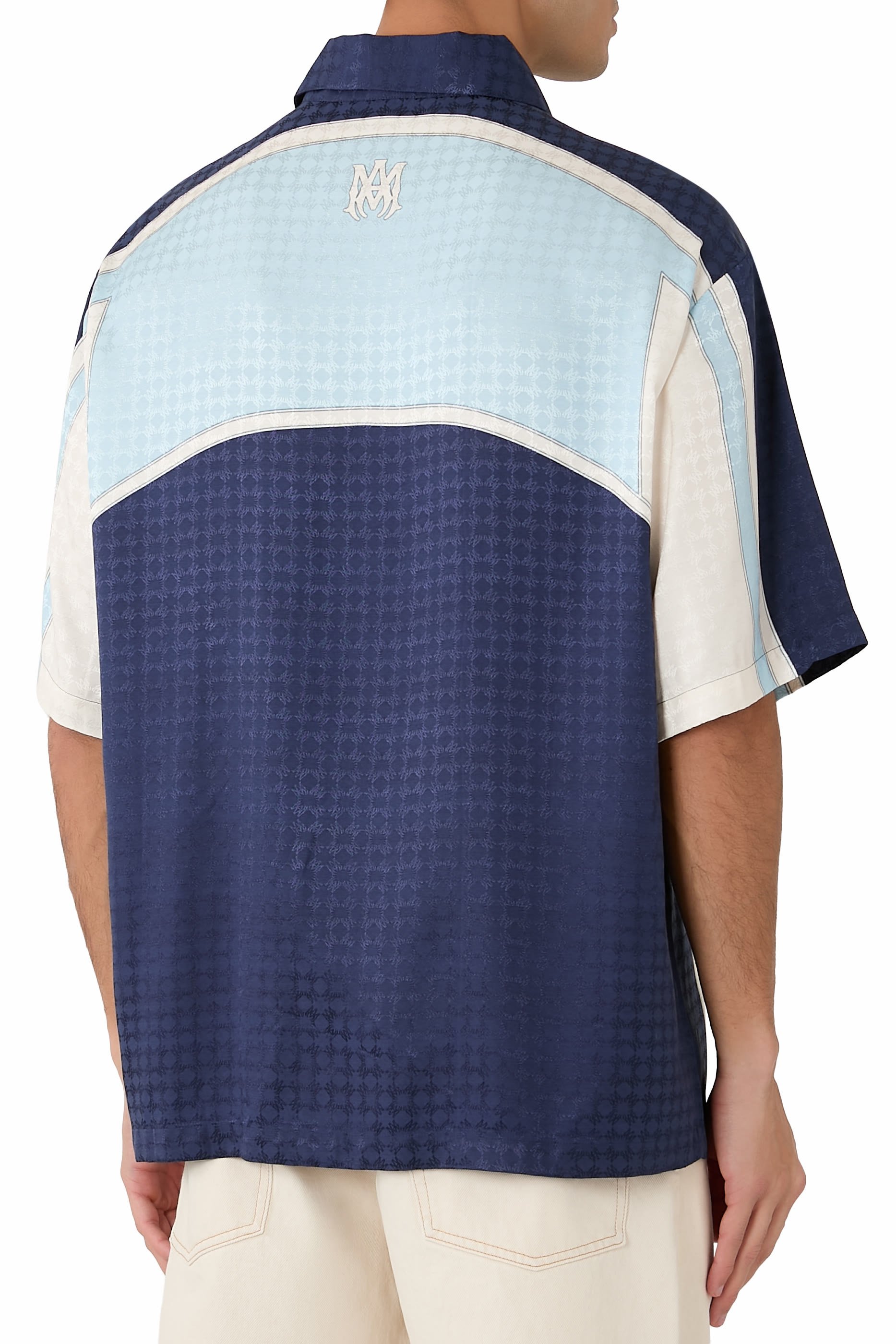 قميص بقصة فضفاضة بياقة مطوية وأجزاء بشعار الماركة