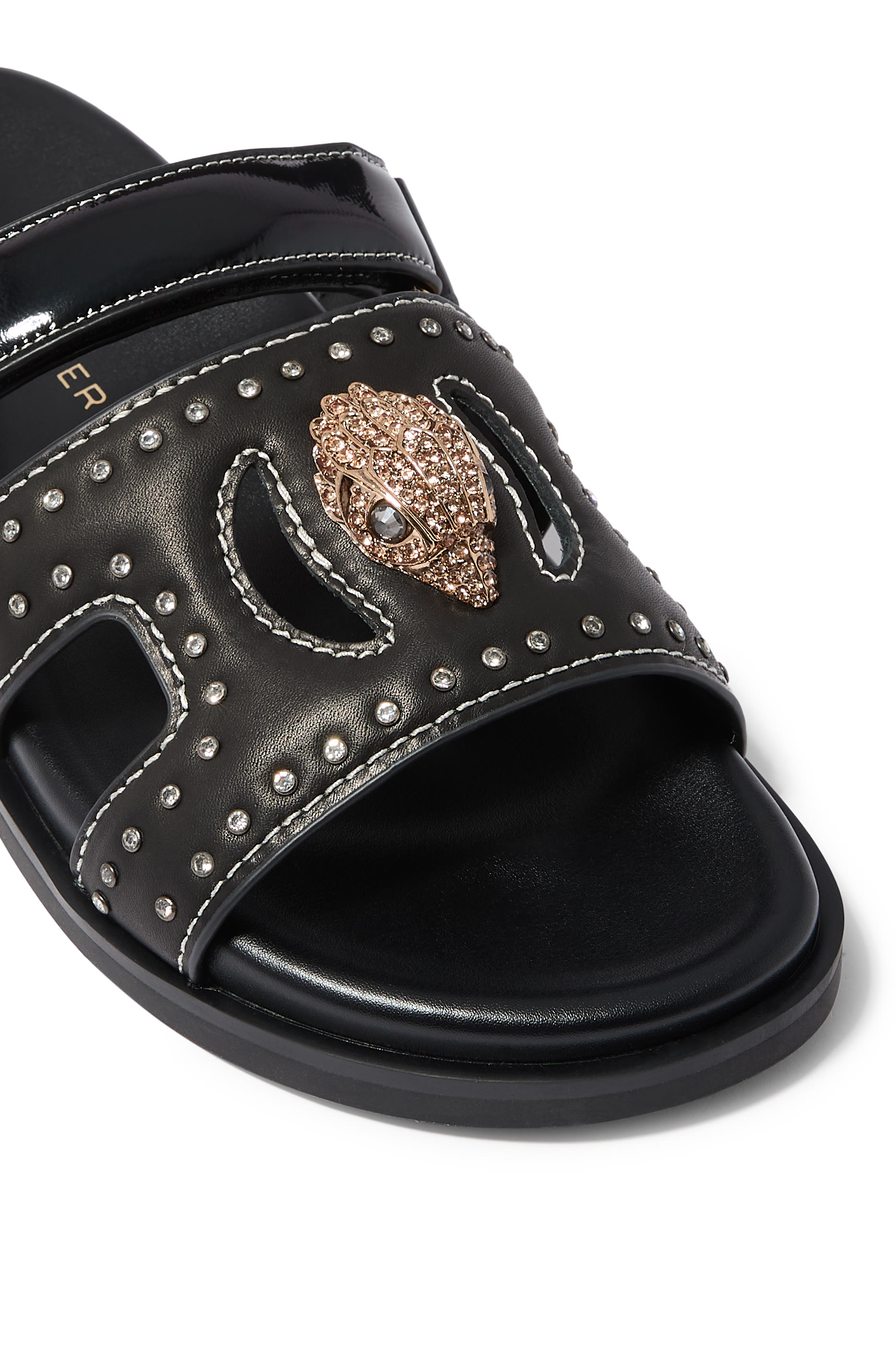 صندل بفتحات مزين بحلية بشعار الماركة 